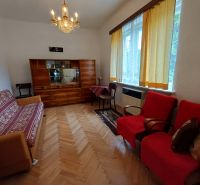 Pekný rodinný s nádherným výhladom. - Obývacia izba v rodinnom dome s podlahou s dreveným dekorom a vintage nábytkom.