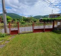 Pekný rodinný s nádherným výhladom. - Garážová brána rodinného domu v Rožňavskom Bystrom obklopená záhradou a panorámou kopcov.