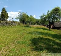 Pozemok s drevenicou na Kysuciach s krásnym výhľadom, Olešná - Záhrada pri chate v Olešnej s dreveným plotom a stromami.