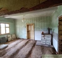 Pozemok s drevenicou na Kysuciach s krásnym výhľadom, Olešná - Interiér chaty s pecou, odkrytá podlaha, zelené steny a závesná lampa.