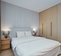 NA PRENÁJOM Luxusný 2+KK, NOVOSTAVBA, Košice- Západ - Spálňa v 2-izbovom byte s posteľou, skrinkami a podlahou s dreveným dekorom.
