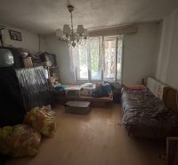 Na predaj starší rodinný dom v obci Budmerice 541m2 - Izba v rodinnom dome s posteľou, televízorom, lustrom a káblovou neporiadkou.