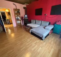 Na predaj starší rodinný dom v obci Budmerice 541m2 - Obývacia izba v rodinnom dome so sedačkou, krbom a dreveným stropom.