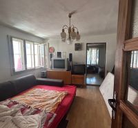 Na predaj starší rodinný dom v obci Budmerice 541m2 - Obývacia izba v rodinnom dome s rozkladacou pohovkou, televízormi a lustrom.