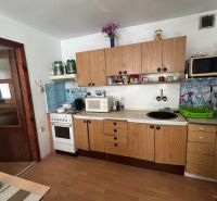 Na predaj starší rodinný dom v obci Budmerice 541m2 - Kuchyňa rodinného domu so sporákom, drevenými skrinkami a mikrovlnkou, v jednoduchom prevedení.