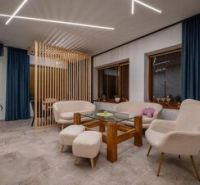 Predaj! Rekreačný apartmán pod Tatrami – Dovalovo - Štýlový interiér s podlahou s dreveným dekorom a pohodlnými kreslami v 1-izbovom byte.
