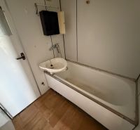 2 izbový byt s 2 balkónmi Topoľčany / VYPLATENA ZALOHA - Kúpeľňa v 2-izbovom byte s vaňou, umývadlom a podlahou s dreveným dekorom.