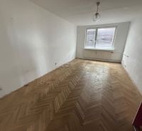 2 izbový byt s 2 balkónmi Topoľčany / VYPLATENA ZALOHA - Izba s veľkým oknom a podlahou s dreveným dekorom v 2-izbovom byte.