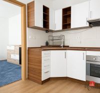 Prenájom 2,5 izbový byt TRENČIANSKA (energie v cene) - Kuchyňa v 3-izbovom byte s bielymi skrinkami a podlahou s dreveným dekorom.