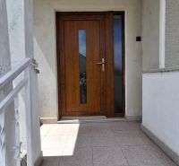 4. izb. RD Čakajovce pri Nitre  - Vchodové dvere rodinného domu v Čakajovciach, lemované svetlými keramickými dlaždicami.