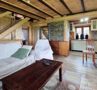 PRIESTRANNÝ DREVODOM S NÁDHERNÝM VÝHĽADOM, ĽUBIETOVÁ,  POZEMOK 2781 M2 - Obývacia izba v rodinnom dome so sedačkou, dreveným nábytkom a kuchyňou v pozadí.
