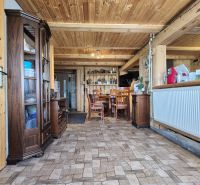 PRIESTRANNÝ DREVODOM S NÁDHERNÝM VÝHĽADOM, ĽUBIETOVÁ,  POZEMOK 2781 M2 - Interiér rodinného domu s dreveným stropom, skrinkami a stolom s drevenými stoličkami.