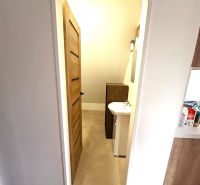 Prenájom, Apartmán v meste Krupina - Kúpeľňa v 2-izbovom byte s umývadlom a svetlou podlahou s dreveným dekorom.
