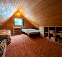 ČAROVNÁ CHALUPA, ĽUBIETOVÁ, 373 M2 - Podkrovná izba v chate s posedením, lôžkami a obkladom z dreva.