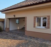 NA PREDAJ – DOM, KDE KAŽDÝ DEŇ JE DOVOLENKA - Garáž rodinného domu v Palárikove so zámkovou dlažbou a malými tujami.