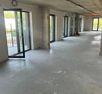 GUTHAUS - 4 izbový byt na Račianskej ulici v Bratislave - Priestranný interiér 4-izbového bytu s betónovou podlahou a veľkými oknami.
