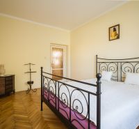 Kúpte si PÔVABNÝ 4i RD na SKVELOM POZEMKU s GARÁŽOU a HALAOU - Na obrázku je izba rodinného domu s kovovou posteľou a drevenou podlahou.