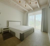 Rodinný dom s krásnym pozemkom, Jablonové - Spálňa s posteľou a skriňou, strop s dreveným dekorom, svetlé závesy pre oknami.