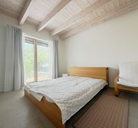 Rodinný dom s krásnym pozemkom, Jablonové - Spálňa v Rodinnom dome s dreveným stropom a jednoduchým nábytkom.
