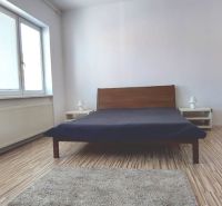 PRENÁJOM: VEĽKOMETRÁŽNY 2 IZBOVÝ BYT S 2 LOGGIAMI, CENTRUM - Spálňa v 2-izbovom byte s podlahou s dreveným dekorom a veľkým oknom.