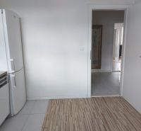 PRENÁJOM: VEĽKOMETRÁŽNY 2 IZBOVÝ BYT S 2 LOGGIAMI, CENTRUM - Kuchyňa v 2-izbovom byte s podlahou s dreveným dekorom a bielou chladničkou.