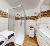  PRENÁJOM 2-izbový byt, centrum mesta s vlastným parkovaním, Topoľčany - Kúpeľňa v 2-izbovom byte s podlahou s dreveným dekorom, sprchou a práčkou.