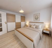  PRENÁJOM 2-izbový byt, centrum mesta s vlastným parkovaním, Topoľčany - Spálňa v 2-izbovom byte s posteľou, skrine a podlahou s dreveným dekorom.