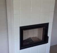 Výnimočná zrubová chata na predaj, Čechy, okr. Nové Zámky - Kachľová pec v chate na podlahe s dreveným dekorom.