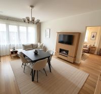2 izbový byt, 58 m² na predaj, Zvolen, Podborová - Obývacia miestnosť v 2-izbovom byte s podlahou s dreveným dekorom a jedálenským stolom.