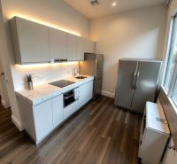 2 izbový byt, 58 m² na predaj, Zvolen, Podborová - Kuchyňa v 2-izbovom byte s podlahou s dreveným dekorom a moderným spotrebičom.