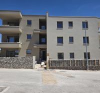 CHORVÁTSKO  - Apartmány (K2) v krásnej dedinke TRIBUNJ - Budova so 4-izbovými bytmi v Tribunji má strohú fasádu a kamenný plot.