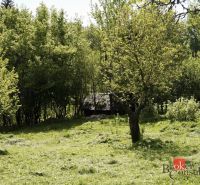 Na predaj pozemok 1898 m² - Horná Lehota, Nízke Tatry - Záhrady v Banskej Bystrici s hustým porastom stromov a trávnatou plochou.