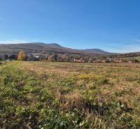 VELČICE - Stavebný pozemok, od 650 m2, okr. Zlaté Moravce - Výhľad na Pozemky - bývanie vo Velčiciach s kopcovitou krajinou v pozadí.