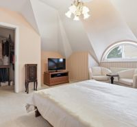 Priestranný rodinný dom s garážou | Vrakuňa, Bratislava - Spálňa v rodinnom dome s manželskou posteľou, šatníkom, televízorom a kreslami.