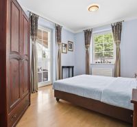 Priestranný rodinný dom s garážou | Vrakuňa, Bratislava - Spálňa v rodinnom dome s posteľou, šatníkovou skriňou a podlahou s dreveným dekorom.