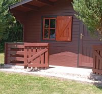 TURANY- rekreačná chata na pozemku 700m2 - Drevená chata so záhradkou na ulici Černík, obklopená zeleňou a trávnikom.