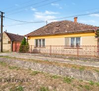 Na predaj 5-izbový rodinný dom, Čierna Voda - Rodinný dom na ulici Čierna Voda v Galante, s výraznou červenou bránou a plotom.