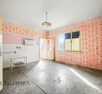 Na predaj 5-izbový rodinný dom, Čierna Voda - Interiér rodinného domu s kvetinovými tapetami, dlaždicovou stenou a stropným svietidlom.