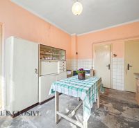 Na predaj 5-izbový rodinný dom, Čierna Voda - Kuchyňa v rodinnom dome s jednoduchým nábytkom, kvetinou a obkladom na stene.