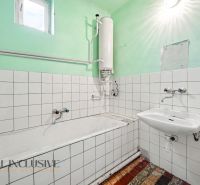 Na predaj 5-izbový rodinný dom, Čierna Voda - Kúpeľňa v rodinnom dome s vaňou, umývadlom a bojlerom, obložená bielymi kachličkami.