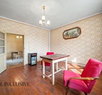 Na predaj 5-izbový rodinný dom, Čierna Voda - Interiér rodinného domu s podlahou s dreveným dekorom, vintage stolom a červenými kreslami.