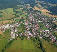 Predaj pozemkov v Badíne (podiely), okres Banská Bystrica - Letecký pohľad na poľnohospodárske a lesné pozemky v okolí Badína, obklopené domami a budovami.
