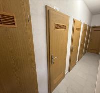 3 izbový byt 86 m2 na predaj,2 balkóny,  novostavba, Zvolen - Dlhá chodba s dverami v 3-izbovom byte, podlaha s dreveným dekorom.
