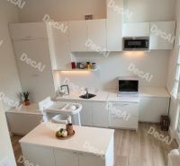 3 izbový byt 86 m2 na predaj,2 balkóny,  novostavba, Zvolen - Kuchyňa v 3-izbovom byte s podlahou s dreveným dekorom, svetlé skrinky a doplnky.