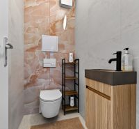 Predaj dizajnový 3-izb byt so záhradou a parkovaním Senec - Kúpeľňa v 3-izbovom byte s keramickým obkladom a dreveným dekorom nábytku.