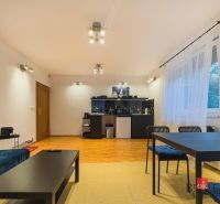 Zariadený 1i apartmán s balkónom na Hradnom kopci - 1-izbový byt s podlahou s dreveným dekorom, sedačkou, stolom a presvetlenými stenami.