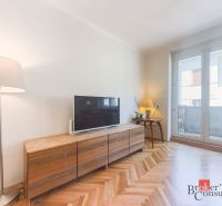 Staromestský 2i byt s balkónom na Palisádach - Obývacia izba v 2-izbovom byte s podlahou s dreveným dekorom a televízorom.