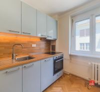 Staromestský 2i byt s balkónom na Palisádach - Kuchyňa v 2-izbovom byte s podlahou s dreveným dekorom a zabudovanými spotrebičmi.