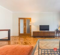 Staromestský 2i byt s balkónom na Palisádach - Obývacia izba v 2-izbovom byte s podlahou s dreveným dekorom a televízorom.