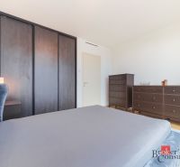 Elegantný 2i byt s lodžiou a výhľadom na Dunaj vo Vydrici - Spálňa v 2-izbovom byte s veľkou skriňou a dreveným dekorom nábytku.
